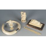 An ivory figure of a sleeping lion, 19th century, on a wooden base, length 12cm,