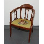 An Edwardian inlaid mahogany tub armchair, with a needlepoint floral decorated seat, height 79cm.