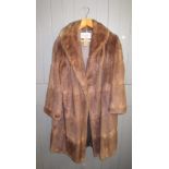 A brown mink three quarter length coat, with silk lining, probably size 14-16.