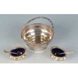 A pair of open silver salts with blue glass liners and spoons,