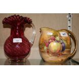 A cranberry glass jug, together with a Royal Winton fruit pattern jug (2)