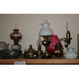 A collection of five oil lamps, some converted to electric including glass shades and funnels