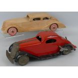 A 1930's clockwork tin-plate streamlined car, possibly by Arnold, 34cm long and a carved beech model