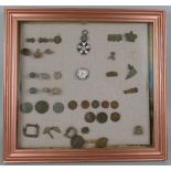 A framed display of metal detector finds, entitled "Waterloo", including coins, bullets, enamalled