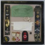 A framed display of WW2 metal and cloth medical badges, and related items, including two Red Cross