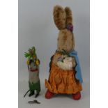 A plush covered figure of a rabbit, in an anthropomorphic pose wearing an orange dress 27cm high and