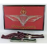 A Parachute Regiment badge in the form of a pin picture, together with three stable belts of various