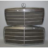 Two Mercedes Benz chrome grills, one lacking the star