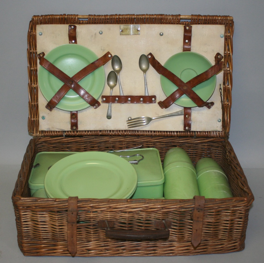 A Coracle picnic basket, the wicker basket containing a pale green service by Stadium for four place