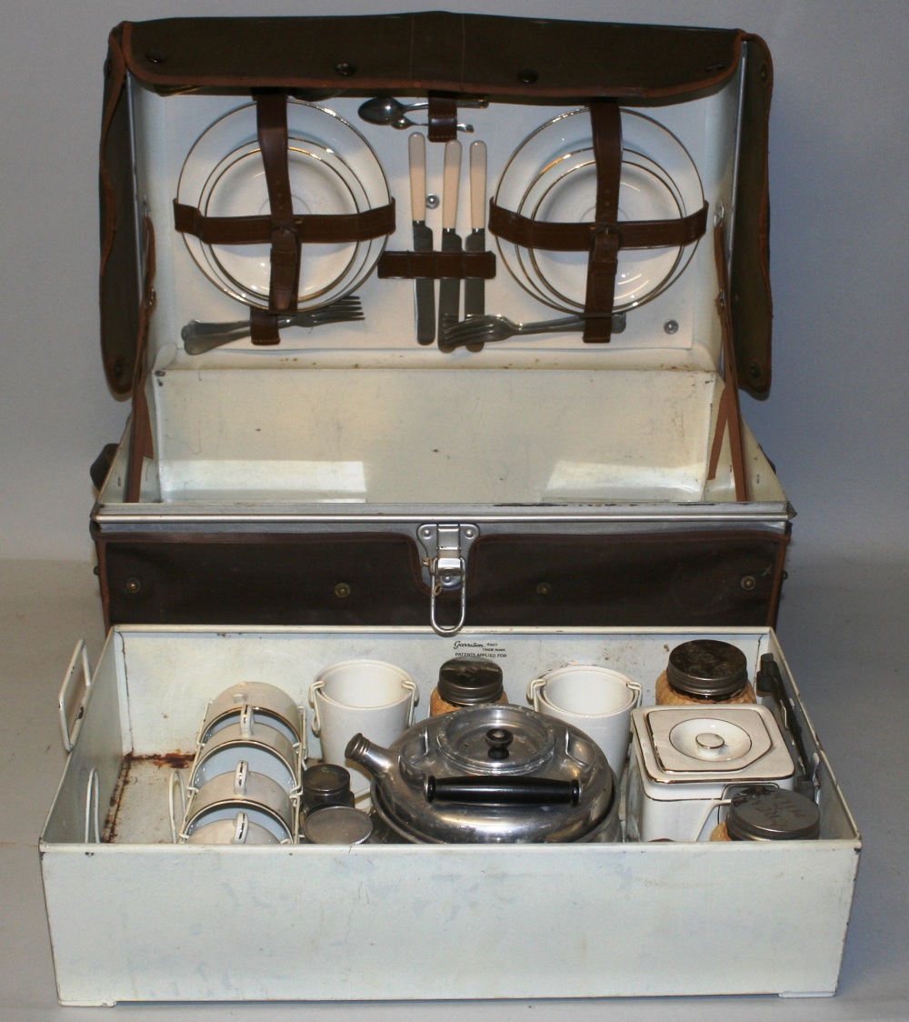 A 1930's Garrison picnic hamper for four place settings, the metal trunk opening to reveal a near