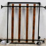 A vintage black painted metal roof rack, with wooden rails, gutter mounted.