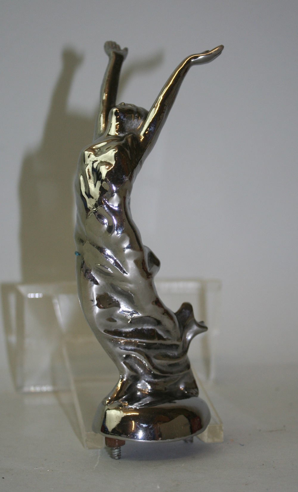 A chrome car mascot, unsigned, depicting a lady stretching, 18cm high