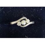 An 18ct gold three stone diamond ring twist claw set with old cut stones