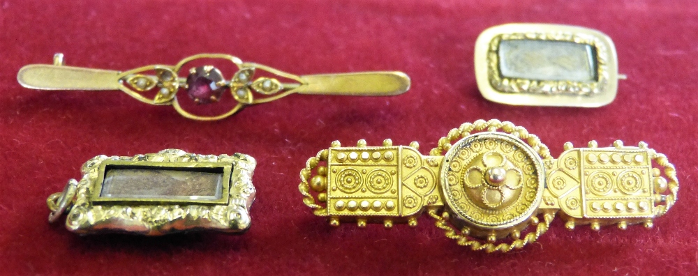 A Victorian gold panel brooch with applied bead work, two gold mourning brooches and a bar brooch (