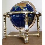 A table globe made from polished hard stone and mounted in a brass frame.