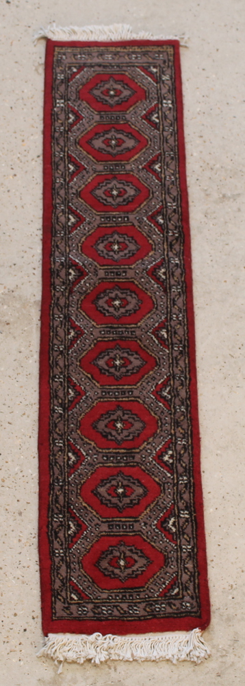 A red and grey ground Uzbek runner with 9 diamonds to the centre 54" x 12"