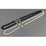 A white and black imitation pearl Chanel style necklace 22"