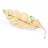 An 18ct yellow gold emerald set leaf shaped brooch 2.4 gramsThe pin is missing