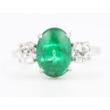 An 18ct white gold emerald and diamond ring, the centre oval stone approx. 2.5ct flanked by
