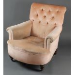 A Howard style armchair upholstered in "peach" coloured Dralon, raised on turned supports There is