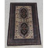 A brown and cream ground Belouch rug with 2 rectangular shaped medallions to the centre within