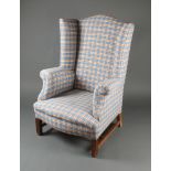 A Georgian style wing armchair upholstered in blue and red chequered material