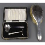 A silver backed hair brush and a cased plated pusher and spoon