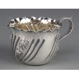A Victorian repousse silver cream jug with floral decoration Maker Charles Edwards London 1888 94