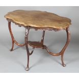 An Edwardian oval shaped mahogany centre table of serpentine outline, raised on shaped supports with