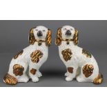 A pair of 19th Century Victorian Staffordshire figures of spaniels with ochre decoration and