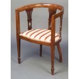 An Edwardian mahogany tub back chair with upholstered drop in seat raised on square tapering