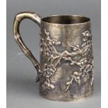 An early 20th Century Chinese silver mug with prunus decoration and bamboo handle 148 grams