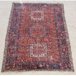 A blue and red ground Persian Heriz rug with stylised diamond to the centre supported by 2 square