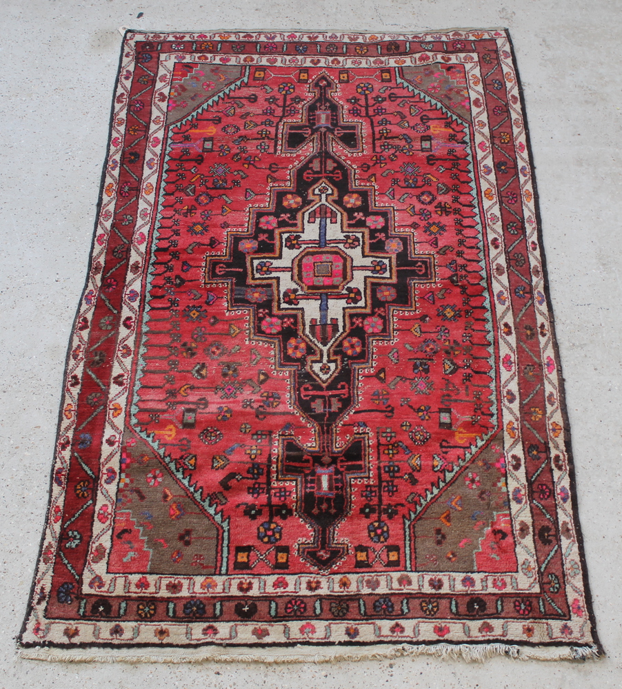 A red and white ground Persian Behbahan rug with central medallion 89" x 53"There is some wear