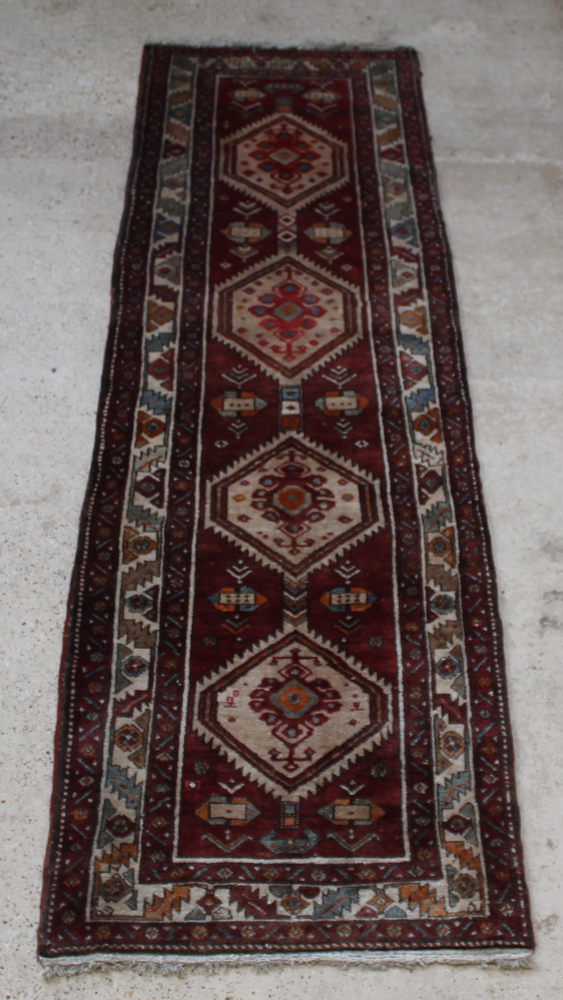 A white and brown ground Persian Nahavand runner with 4 diamonds to the centre 131" x 40" Signs of