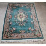 A green ground and floral patterned Chinese carpet 121" x 83" There is slight staining to this
