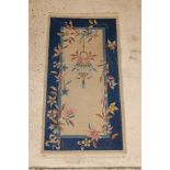 An Indian blue and white ground rug decorated a lantern to the centre 59" x 31" There is some
