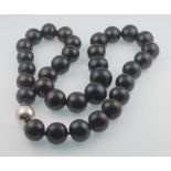 A string of black cultured pearls with silver magnetic clasp