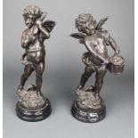 A pair of bronzed figures of a boy drummer and violinist, raised on black marble socle bases 12"