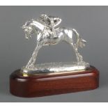 A filled silver trophy in the form of a jockey up, on a wooden plinth 9"