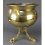 A circular planished brass planter/jardiniere raised on dolphin supports 19"h x 15 1/2" diam.