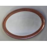 An oval bevelled plate wall mirror contained in a mahogany frame 28"h x 40"w