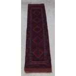 A red and blue ground Meshwani runner with 5 diamonds to the centre 104" x 24"