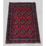 A red and blue ground Belouch rug with 9 octagons to the centre 57" x 36"