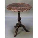 A 19th Century circular oak snap top wine table raised on a baluster turned column with tripod