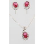 A silver and cubic zirconia pendant and earring set with pink past stones