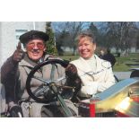 Sir Stirling Moss and Sue Moss, a coloured photograph of the couple seated in a vintage motorcar