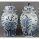 A pair of Chinese Provincial baluster vases and covers with shi shi finials and dragons amongst