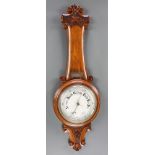 A 19th Century aneroid barometer with porcelain dial contained in a carved oak wheel case The
