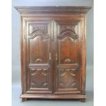 A 17th/18th Century Continental oak armoire of panelled construction with moulded cornice, the